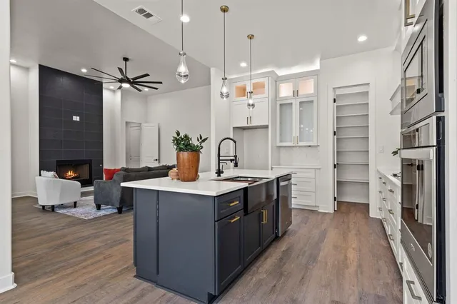 a kitchen with stainless steel appliances a stove refrigerator and wooden floor