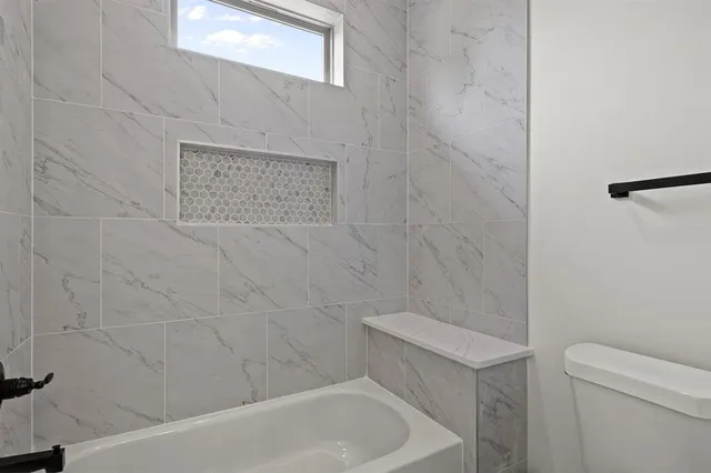 a bathroom with a toilet and bathtub