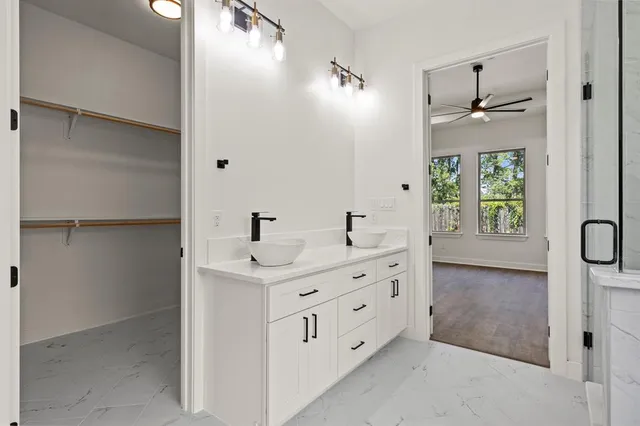 a bathroom with a double vanity sink a window and mirror
