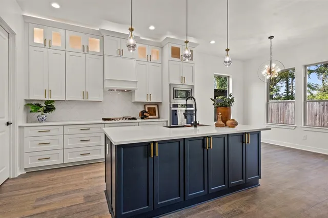 a kitchen with white cabinets and window