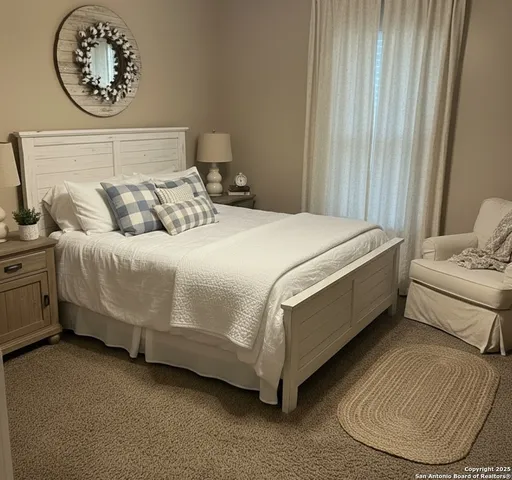 a bed sitting in a bedroom next to a window and a chandelier