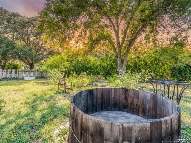 a view of a backyard with wooden fence