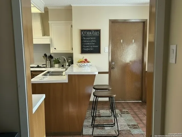 a view of kitchen with sink and refrigerator
