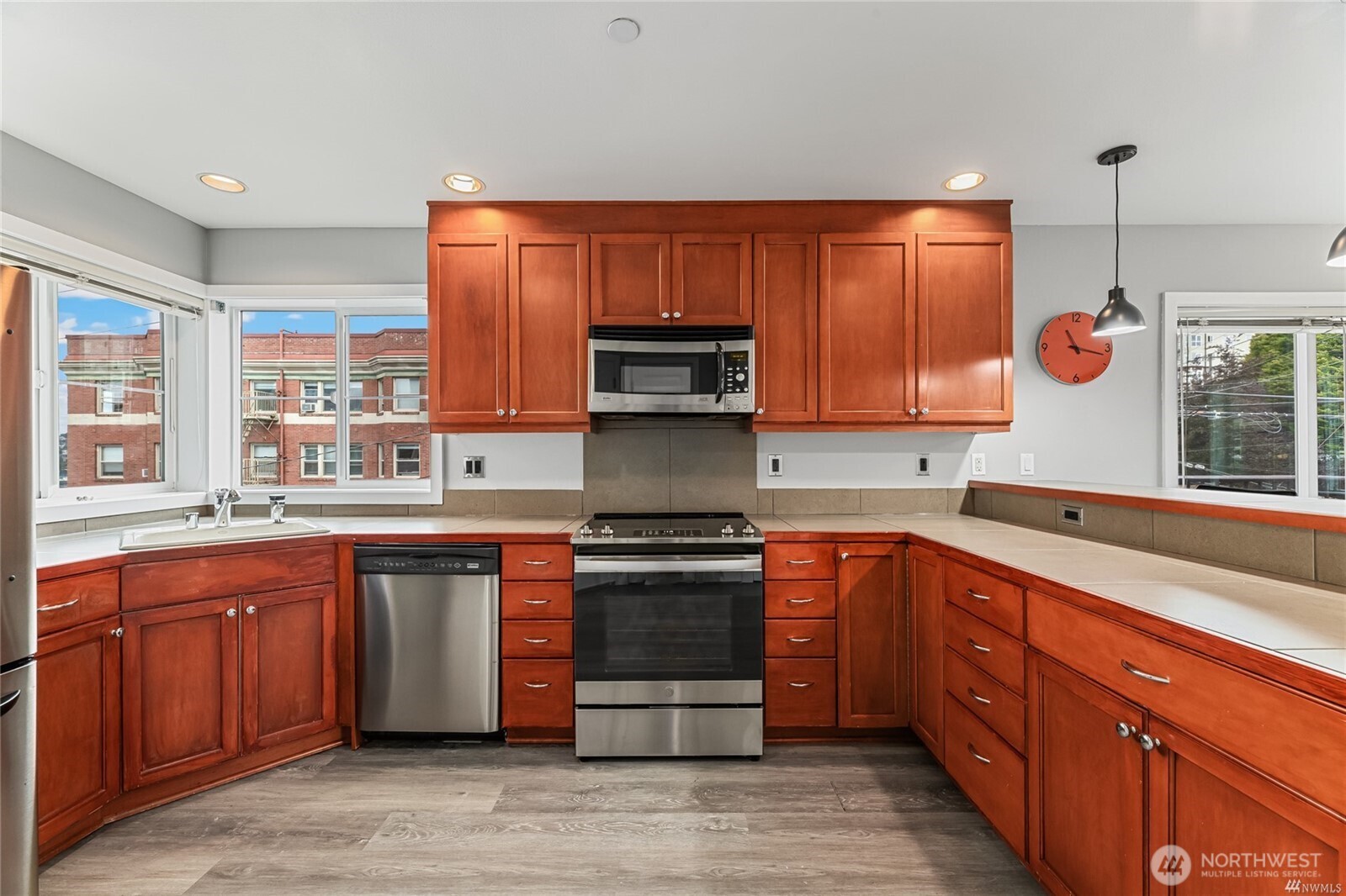 321 East Thomas Street, Unit 303 Seattle, WA 98102 - Photo 6 of 18 a kitchen with stainless steel appliances granite countertop wooden cabinets and a stove top oven