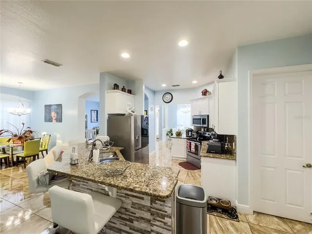 a kitchen with stainless steel appliances granite countertop a sink and a refrigerator