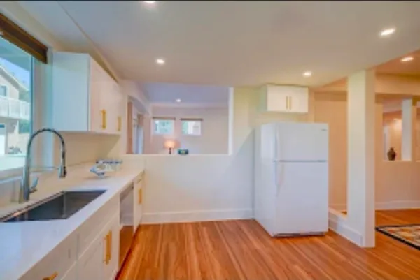 a kitchen with a sink and wooden floor