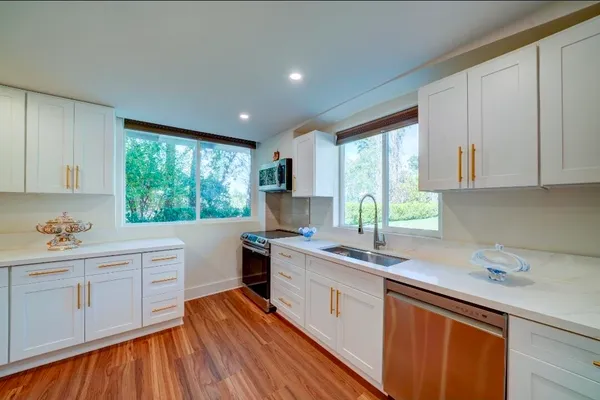 a kitchen with a sink window and cabinets