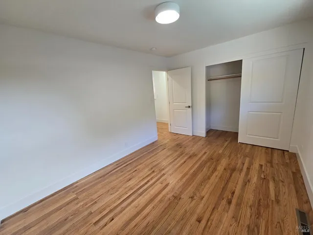 a view of a room with wooden floor and white walls