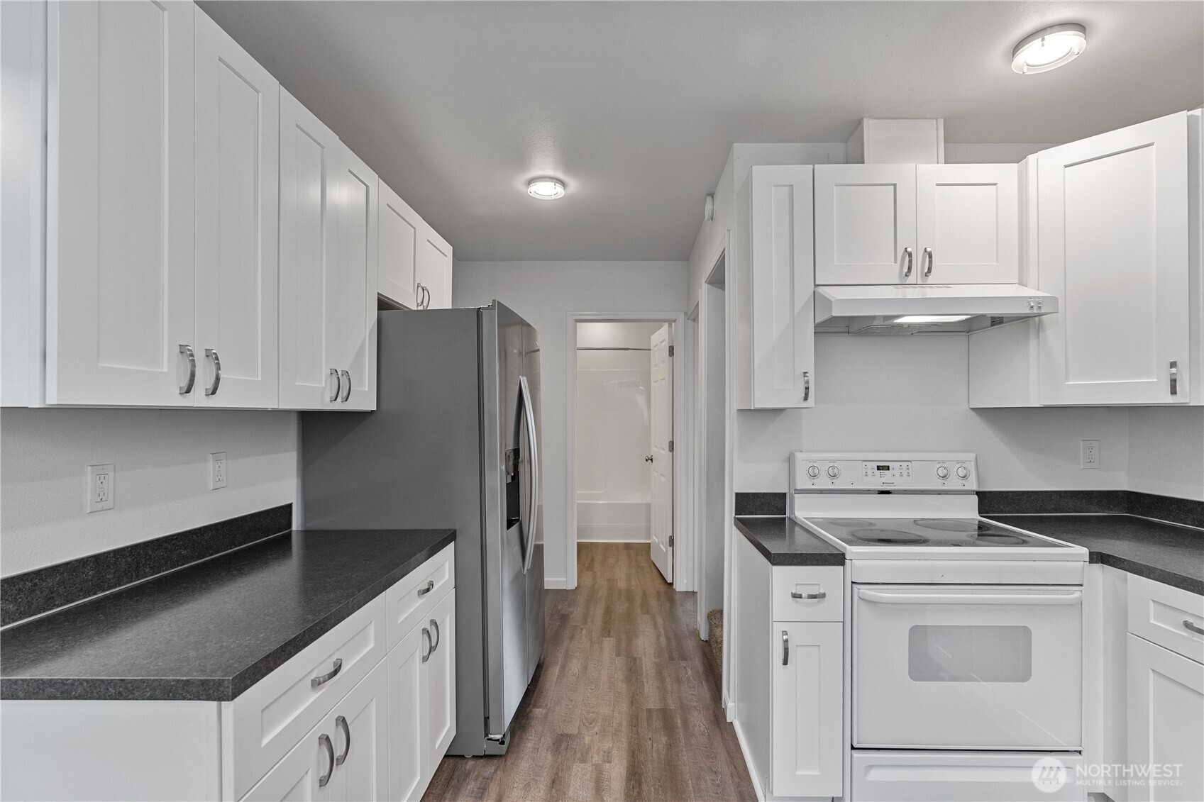 508 30th Street Hoquiam, WA 98550 - Photo 8 of 40 a kitchen with white cabinets and black appliances