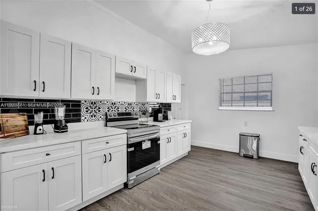 a kitchen with cabinets stainless steel appliances a sink and wooden floor