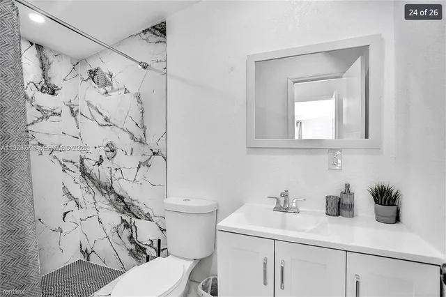 a bathroom with a toilet sink and mirror
