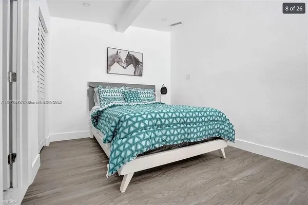 a bed sitting in a bedroom next to a small bathroom