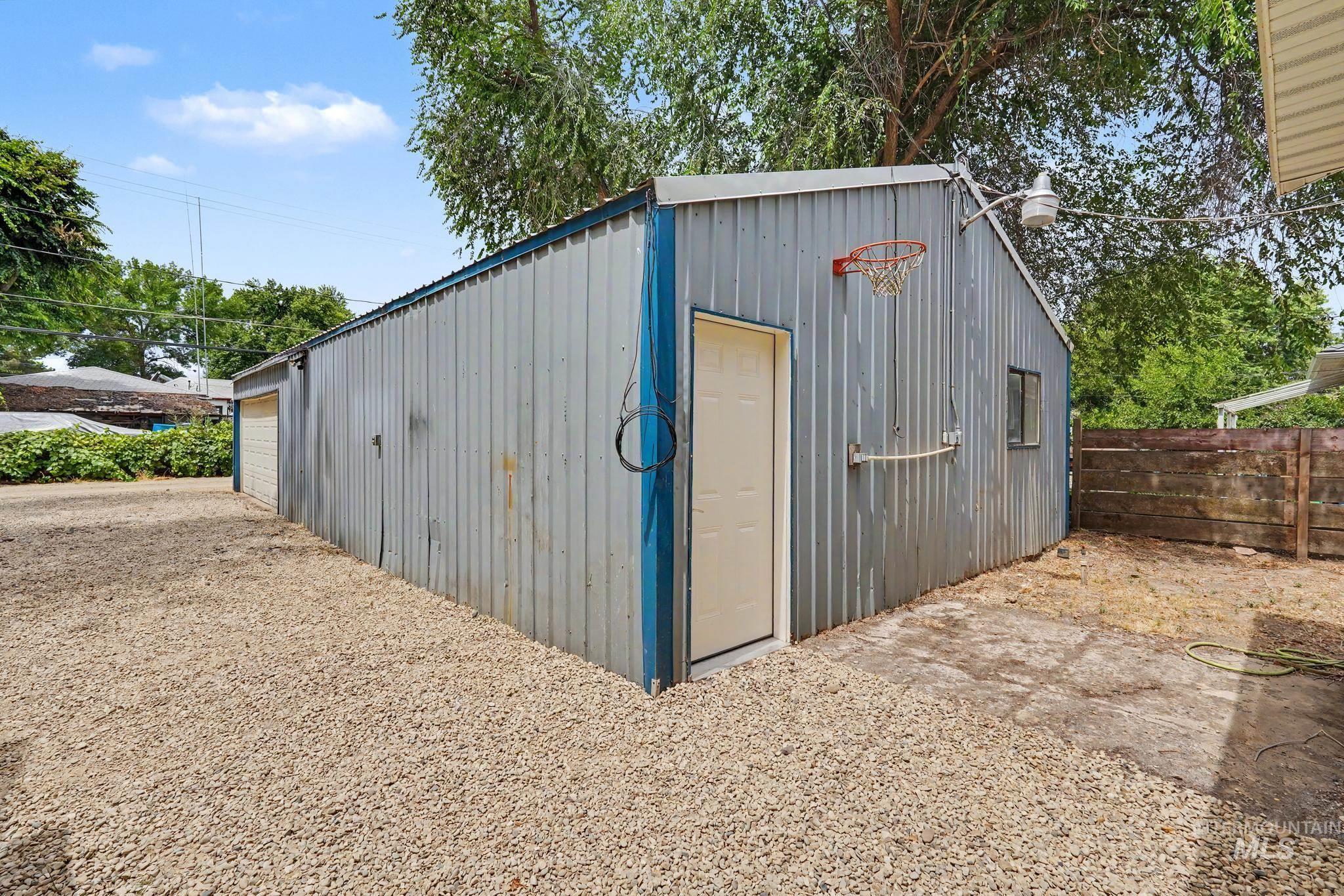 1023 State Street Weiser, ID 83672 - Photo 21 of 25 Corrugated metal outbuilding featuring a side entry door, single window, and an attached basketball hoop