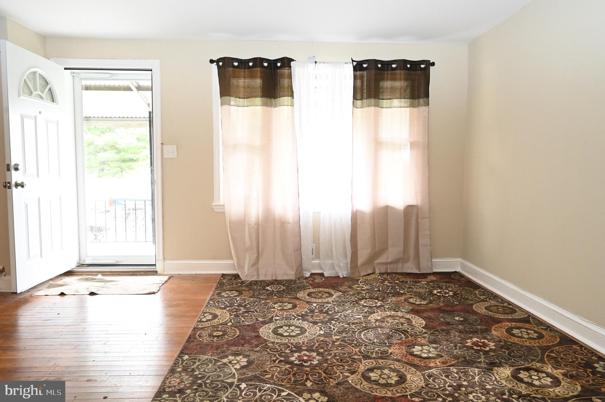 2458 Nevada Street Baltimore, MD 21230 - Photo 3 of 19 a view of a bedroom with wooden floor and windows