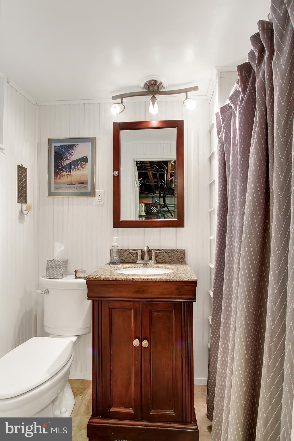 3605 Ednor Road Baltimore, MD 21218 - Photo 17 of 23 a bathroom with a toilet a sink and mirror