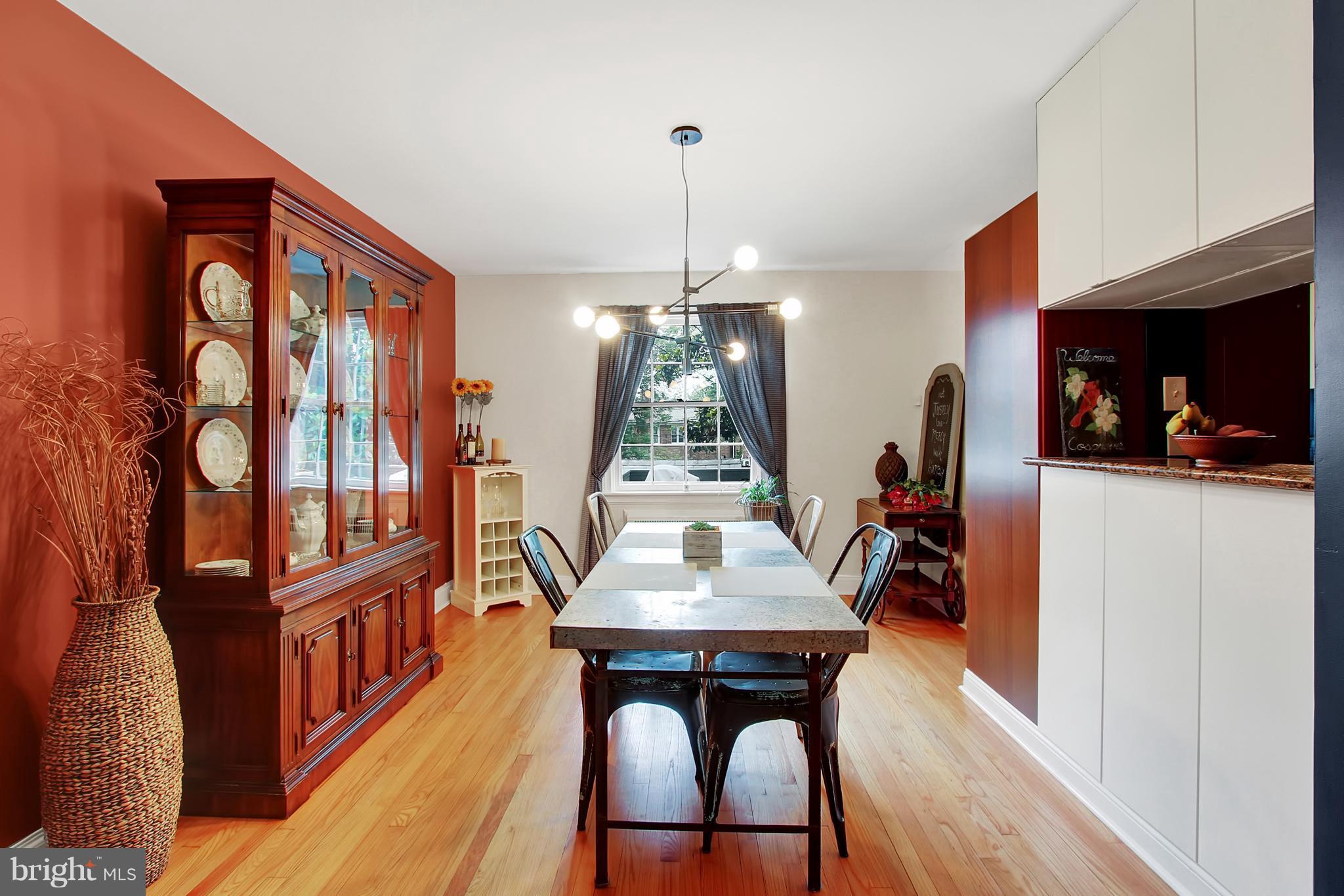 3605 Ednor Road Baltimore, MD 21218 - Photo 7 of 23 a dining room with wooden floor a chandelier a wooden table and chairs
