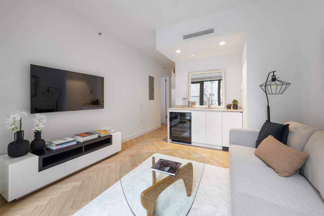 378 Broome Street, Unit 2 Manhattan, NY 10013 - Photo 8 of 13 a living room with furniture and a flat screen tv