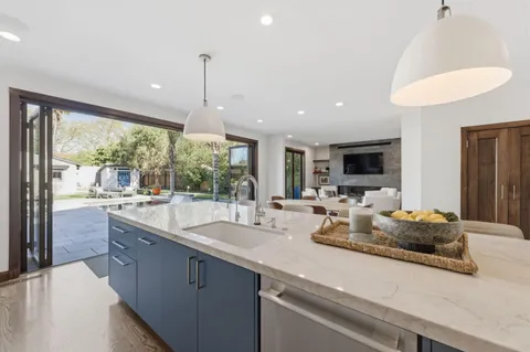 a kitchen with sink refrigerator and large window