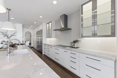 a kitchen with stainless steel appliances a sink stove and cabinets