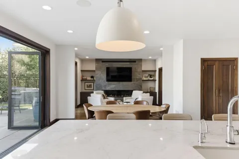 a living room with furniture a fireplace and a large window