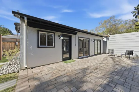 a view of house with backyard and trees in the background
