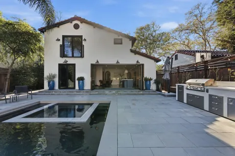 a view of a house with barbeque oven and wooden fence