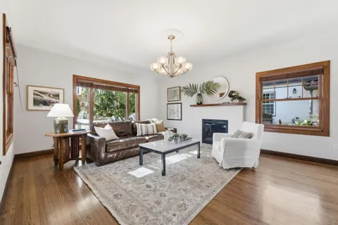 a living room with furniture a fireplace and a chandelier