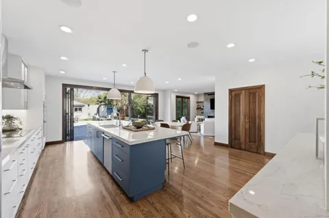 a kitchen with a stove and wooden floor