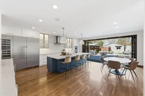 a living room with stainless steel appliances kitchen island granite countertop furniture wooden floor and a view of kitchen