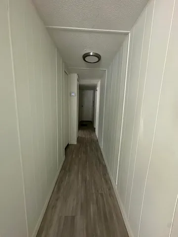 a view of a hallway with wooden floor