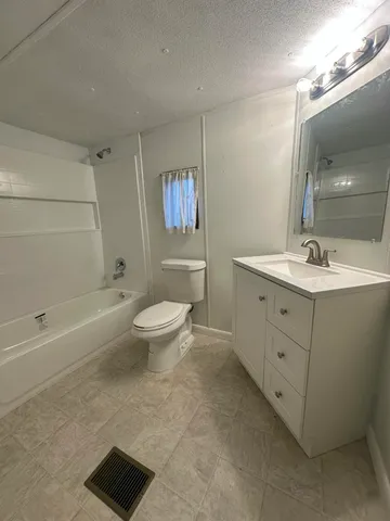 a spacious bathroom with a toilet sink and mirror