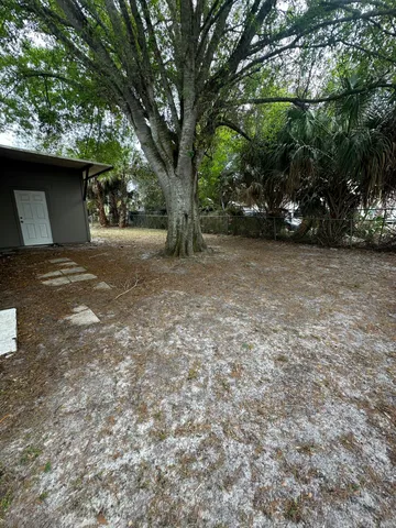 a view of backyard of house with trees