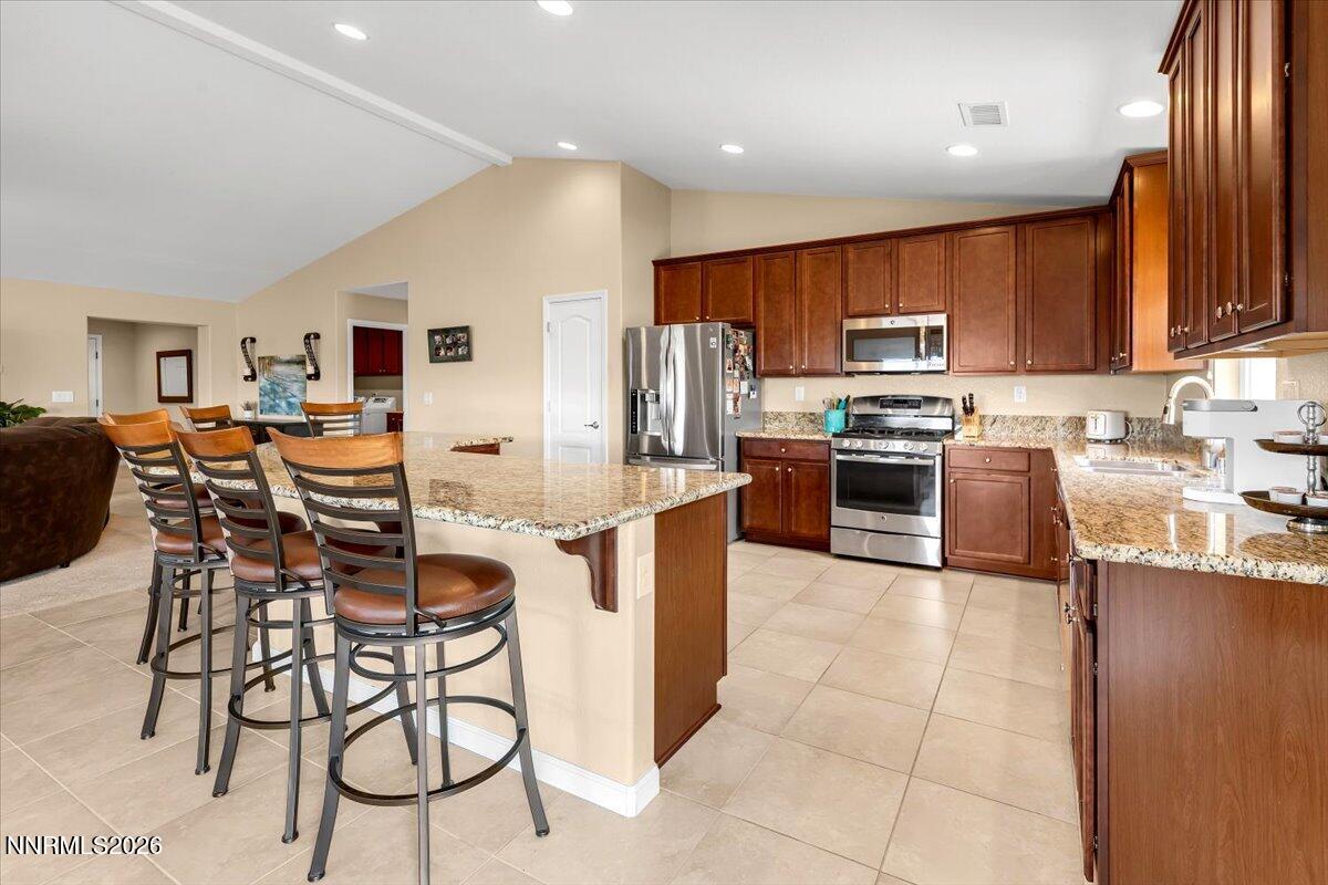 104 Bethpage Road Dayton, NV 89403 - Photo 11 of 65 a kitchen with stainless steel appliances a stove a sink a oven a dining table and chairs