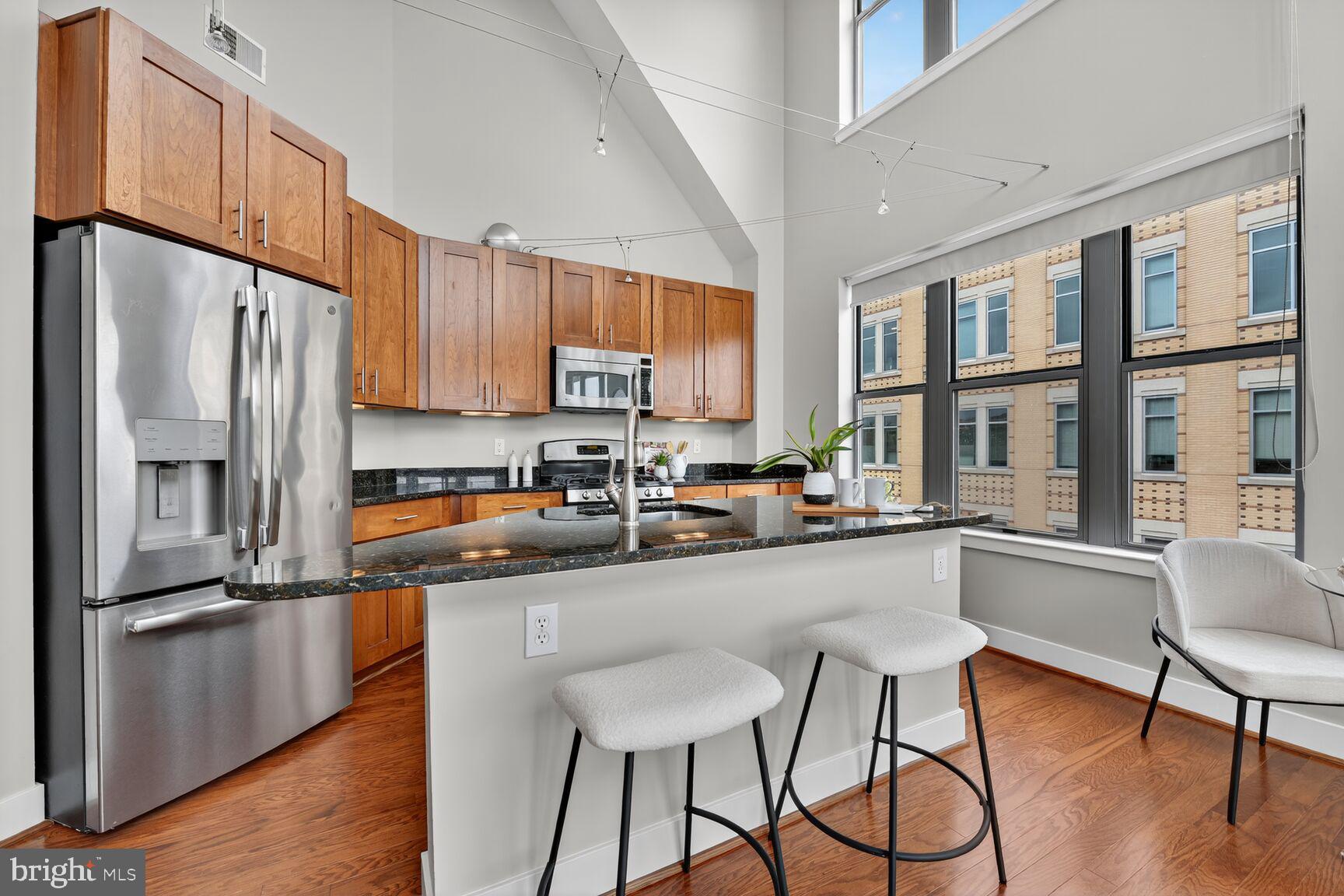 1800 Wilson Boulevard, Unit 449 Arlington, VA 22201 - Photo 12 of 99 a kitchen with stainless steel appliances a refrigerator a stove a sink dishwasher and cabinets with wooden floor