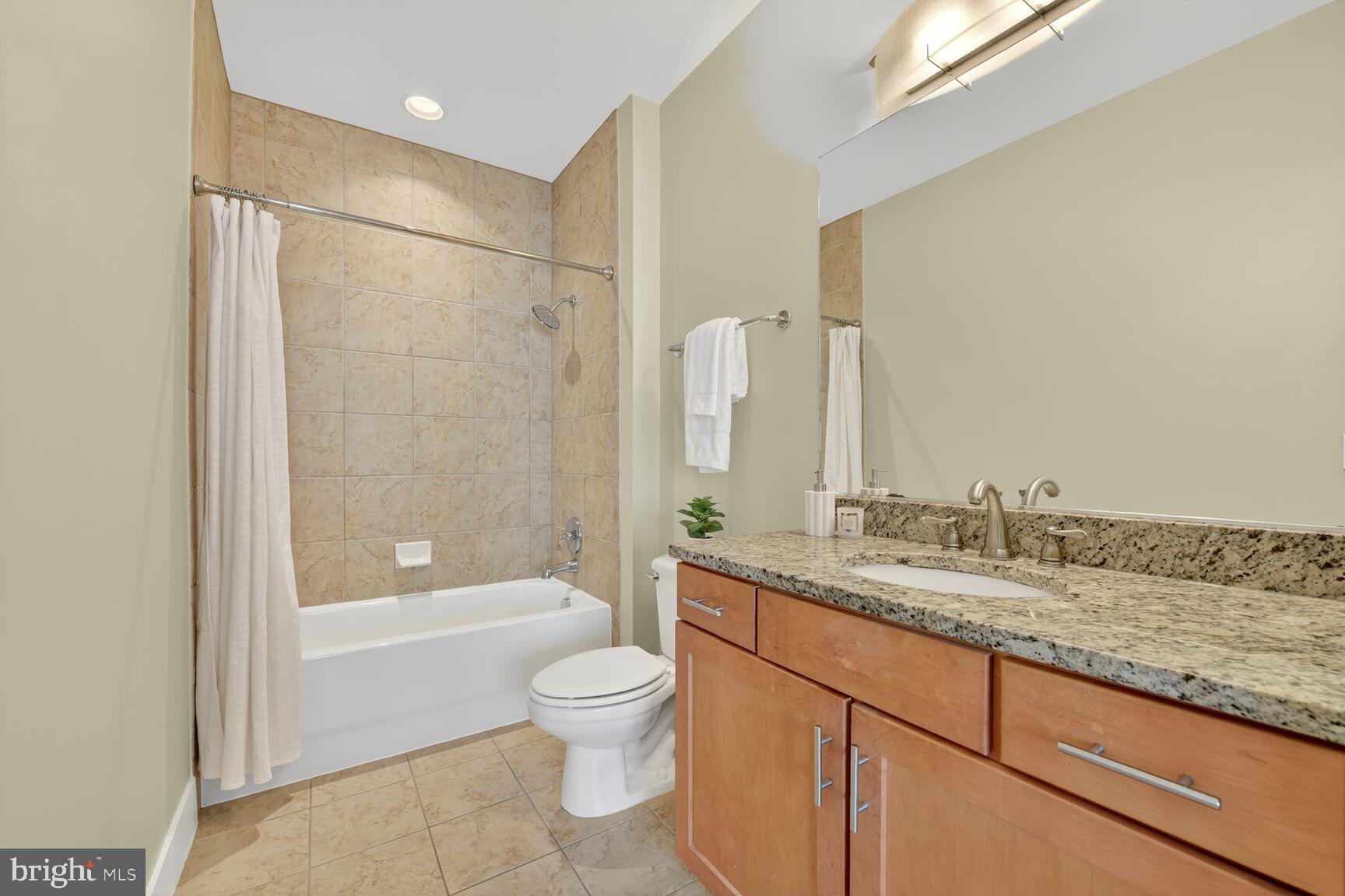1800 Wilson Boulevard, Unit 449 Arlington, VA 22201 - Photo 44 of 99 a bathroom with a granite countertop sink toilet and shower