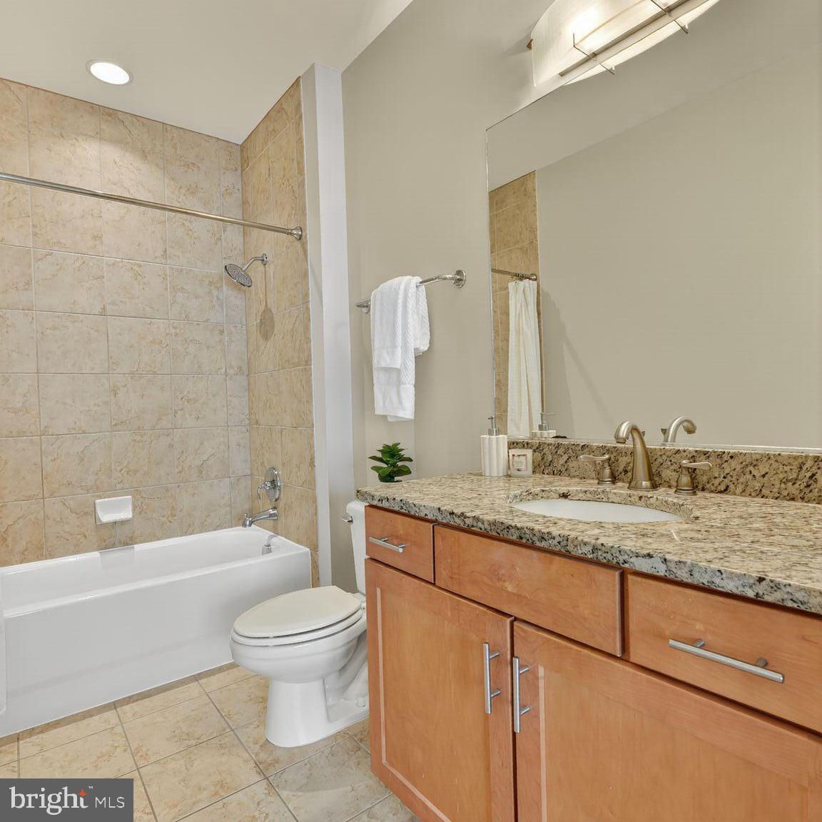 1800 Wilson Boulevard, Unit 449 Arlington, VA 22201 - Photo 45 of 99 a bathroom with a granite countertop sink a toilet and bathtub