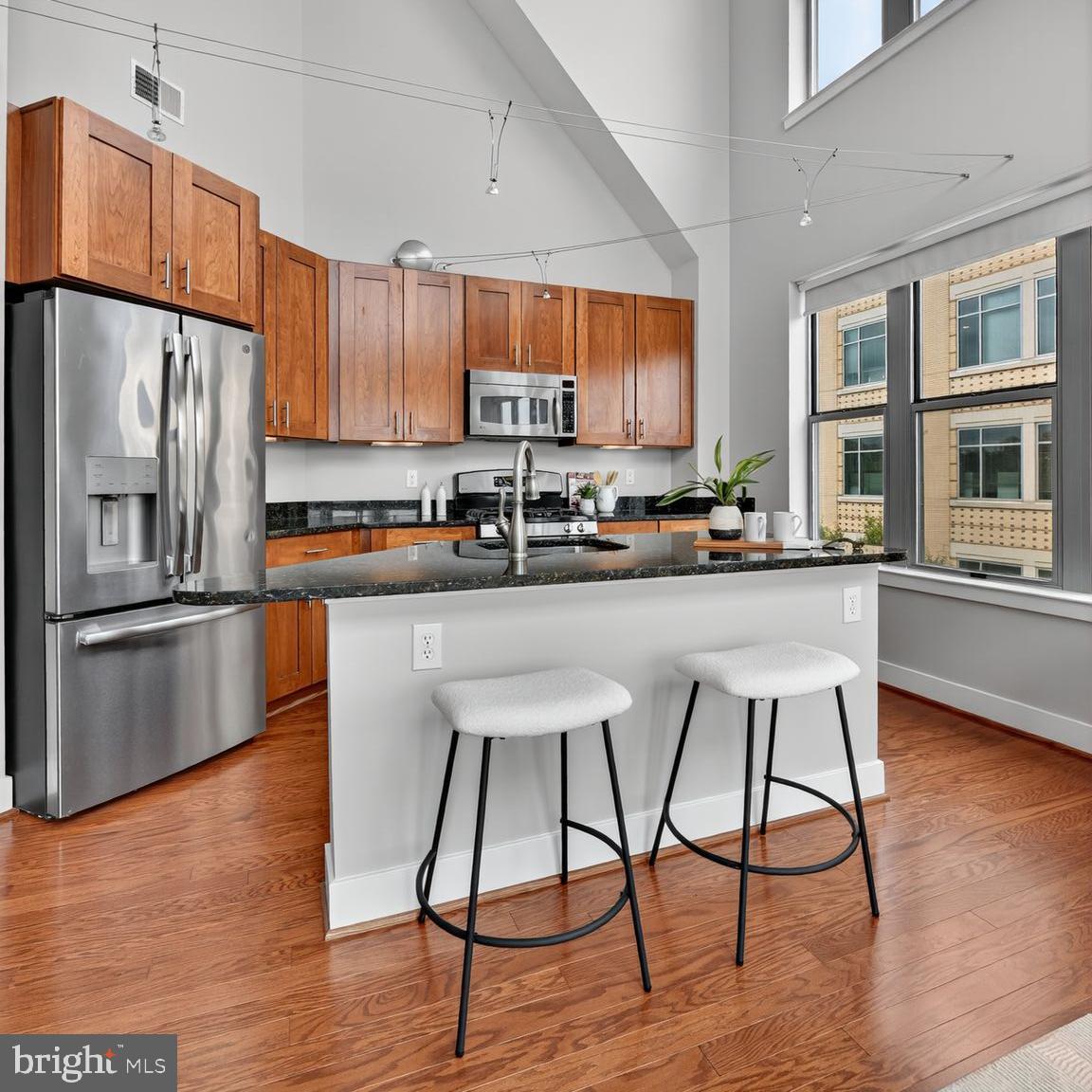 1800 Wilson Boulevard, Unit 449 Arlington, VA 22201 - Photo 9 of 99 a kitchen with stainless steel appliances granite countertop a refrigerator a stove a sink dishwasher a stove and white cabinets with wooden floor