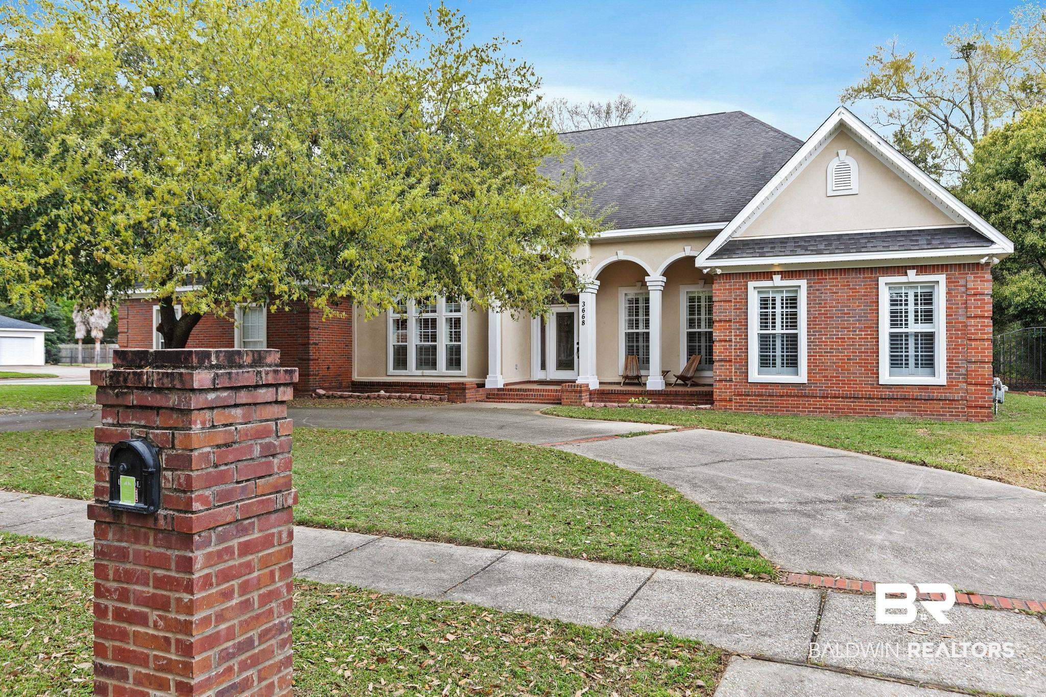 3668 Claridge Road North Mobile, AL 36608 - Photo 4 of 100 View of front of property featuring a shingled roof, a front lawn, brick siding, and stucco siding