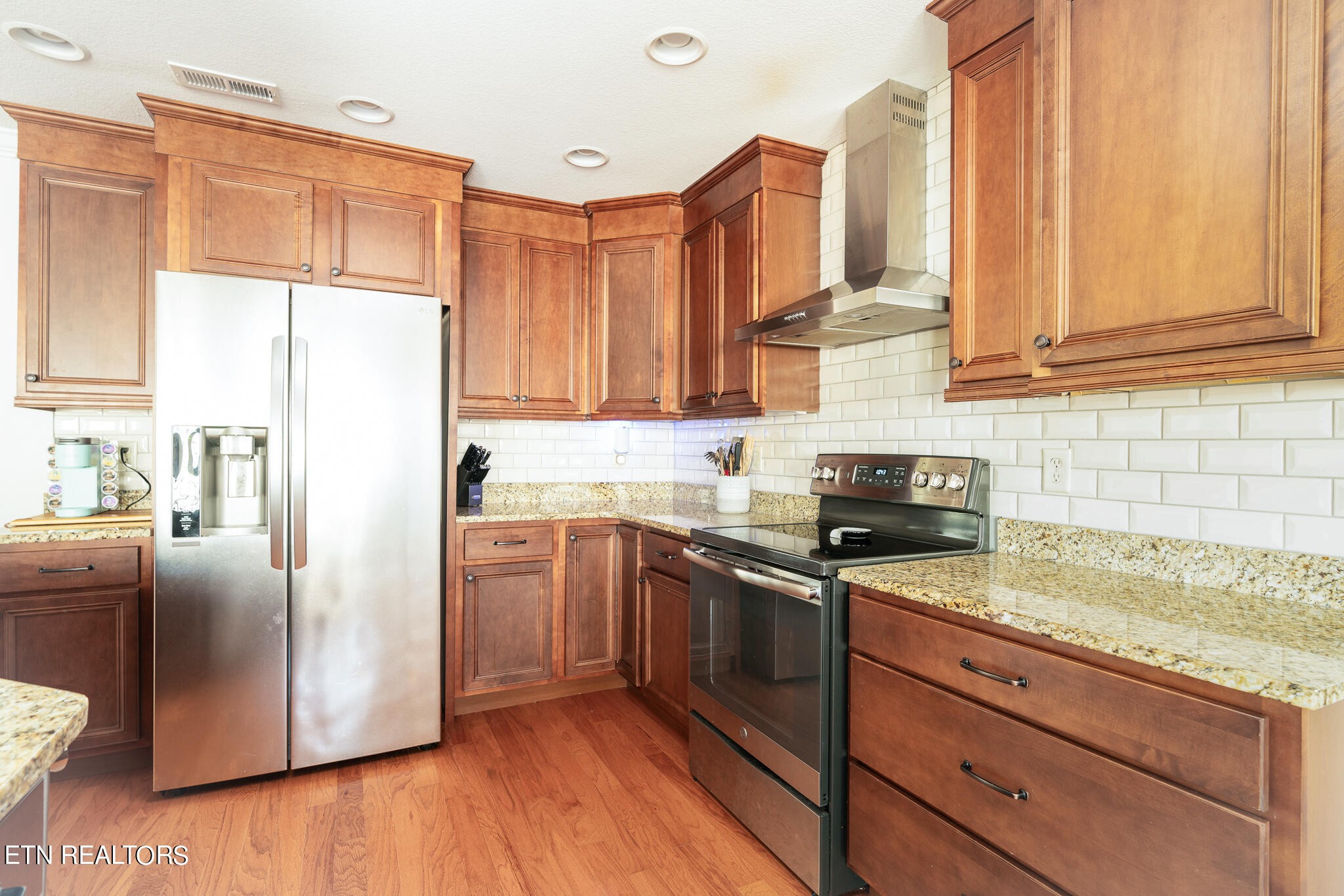 1143 Houston Springs Road Greenback, TN 37742 - Photo 12 of 34 a kitchen with stainless steel appliances granite countertop a refrigerator a sink dishwasher a stove with wooden cabinets and floor
