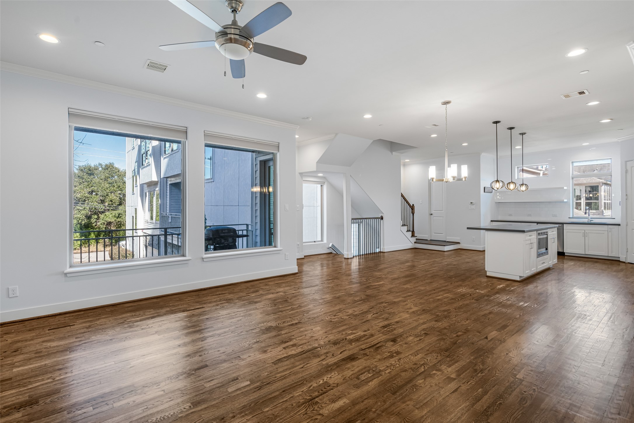 a view of an empty room with window and wooden floor