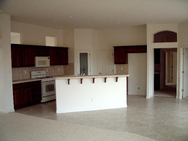 1621 Caliterra Way Reno, NV 89521 - Photo 2 of 4 a large kitchen with stainless steel appliances granite countertop a stove and a refrigerator