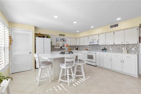 a kitchen with a table chairs refrigerator and cabinets