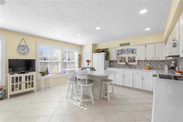 a kitchen with stainless steel appliances a stove a sink a oven a table and chairs