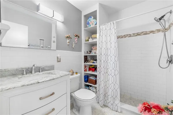 a bathroom with a granite countertop sink toilet and shower