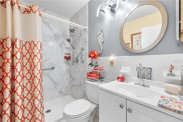 a bathroom with a sink vanity mirror and toilet
