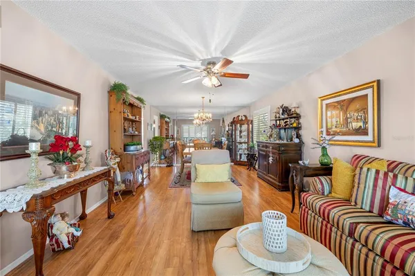 a living room with furniture flowers and a chandelier
