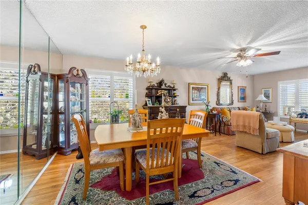 a living room with furniture a chandelier and a dining table