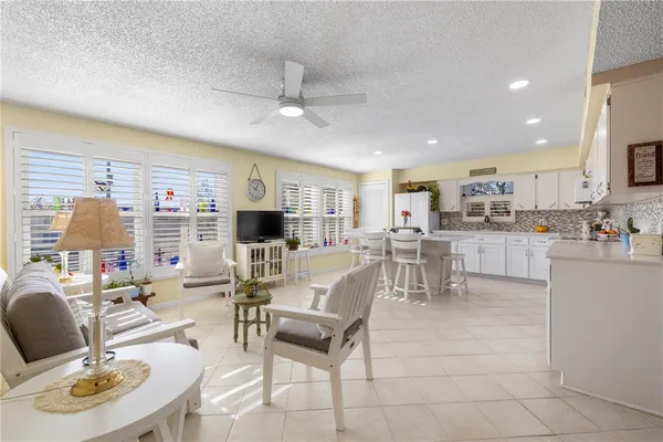 a living room with lots of furniture and kitchen view