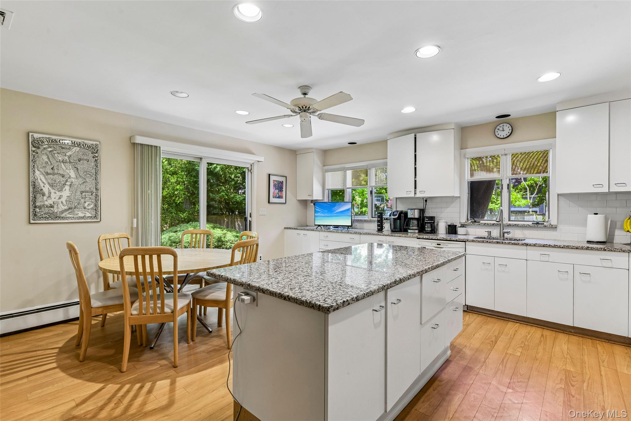 100 Hewlett Neck Road Woodmere, NY 11598 - Photo 13 of 45 a kitchen with granite countertop white cabinets stainless steel appliances dining table and chairs