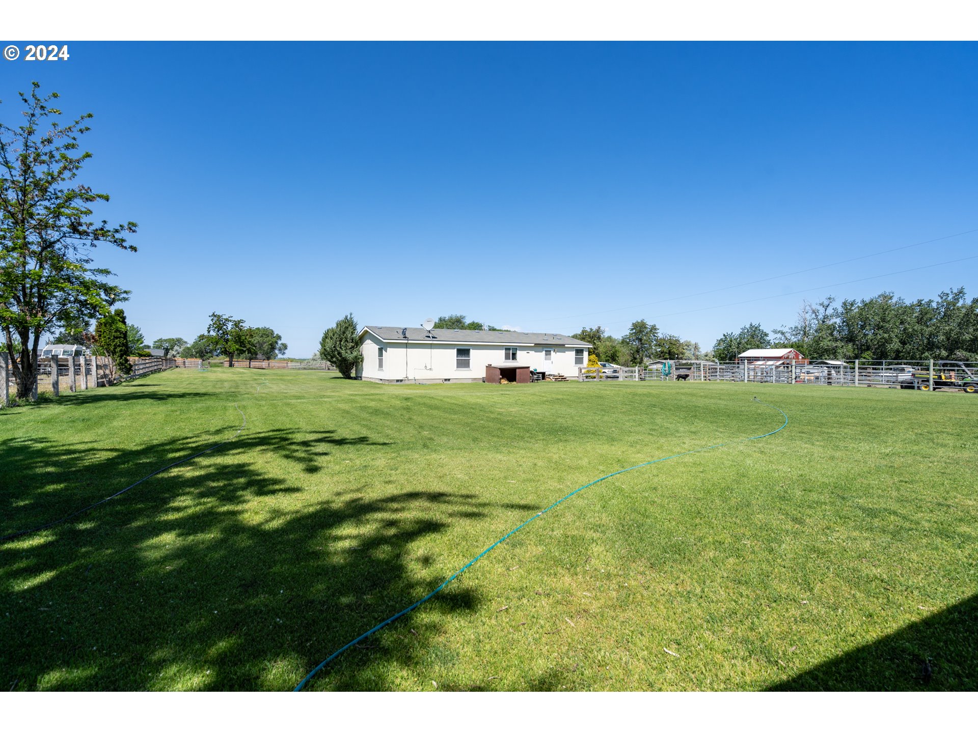 81385 North Golda Road Hermiston, OR 97838 - Photo 28 of 40 a backyard of a house with lots of green space and trees